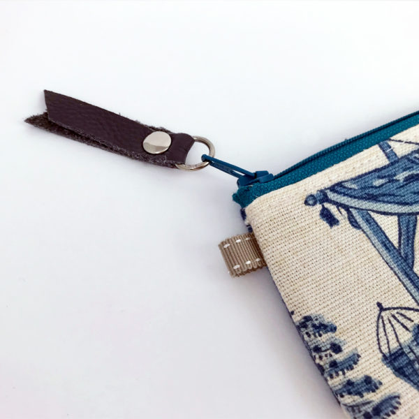 Close up image of the cowhide leather fob on the zipper