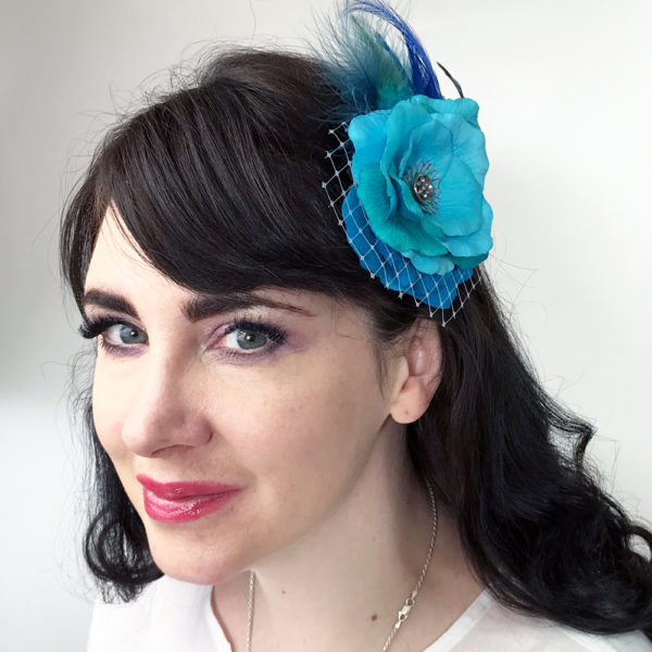 Woman wearing a turquoise rose hair clip fascinator in her hair