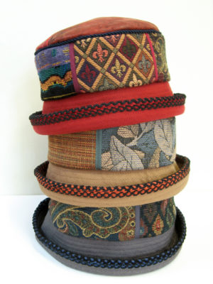3 Aubery design hats stacked on top of each other grey, beige and red