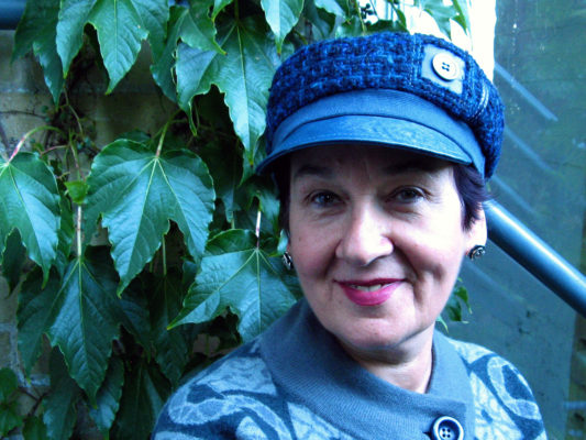 A client wearing a blue Abbey Road cap outside in front of a vine of leaves