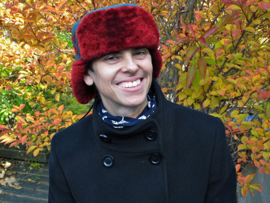 A woman wearing her new red and teal Winter Wave hat