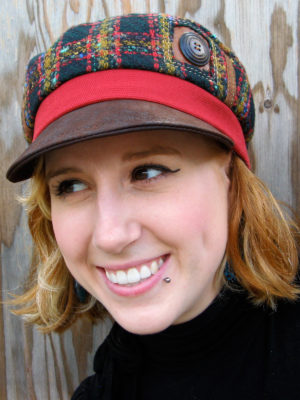 A close up of woman wearing a Abbey Road Cap in colours red brown and forest green