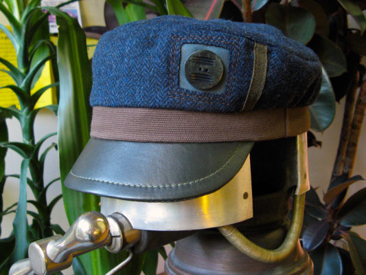 An Abbey Road Cap in navy brown and green on a hat stretcher