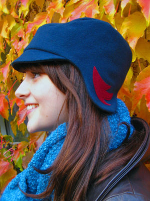 Head shot of a woman wearing the Amelia hat design in dark teal colours.