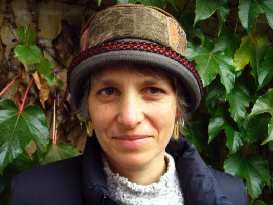 A woman wearing her new grey and taupe coloured Aubery Hat outside.