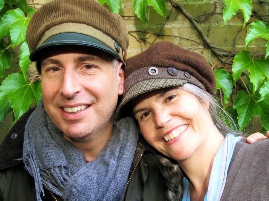 Happy client wearing his new brown Abbey Road cap beside Gwendolyne who's wearing a Donavan cap.