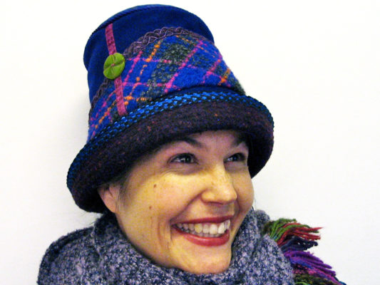 A close up of woman wearing a Estonian Hat in the colours blue and purple
