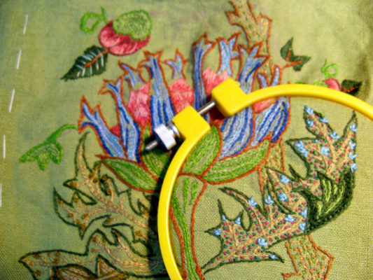 Yellow embroidery hoop close up of leaves and flower bloom
