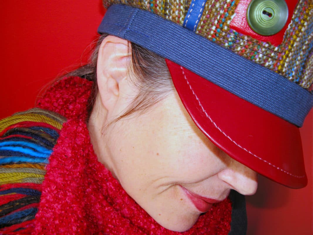 Close up of Gwendolyne wearing a red peak Abbey Road Cap
