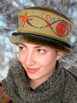 A close up of woman wearing a soft lime Rusalka Hat with a olive coloured fur rim