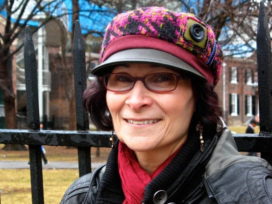 Woman with hot pink wool peaked cap on outside