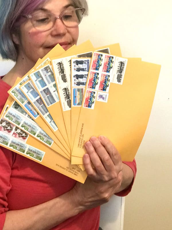 Gwendolyne holding up envelopes with vintage postage stamps
