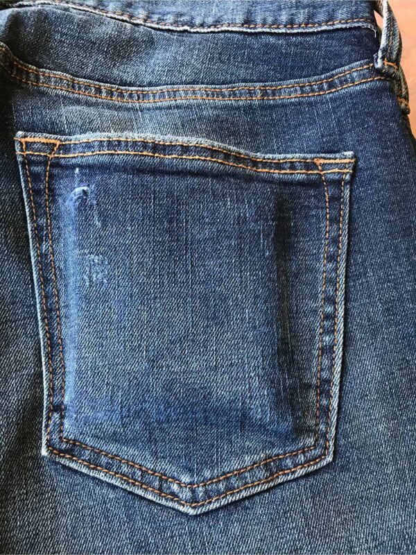 Aged detail of back jean pocket